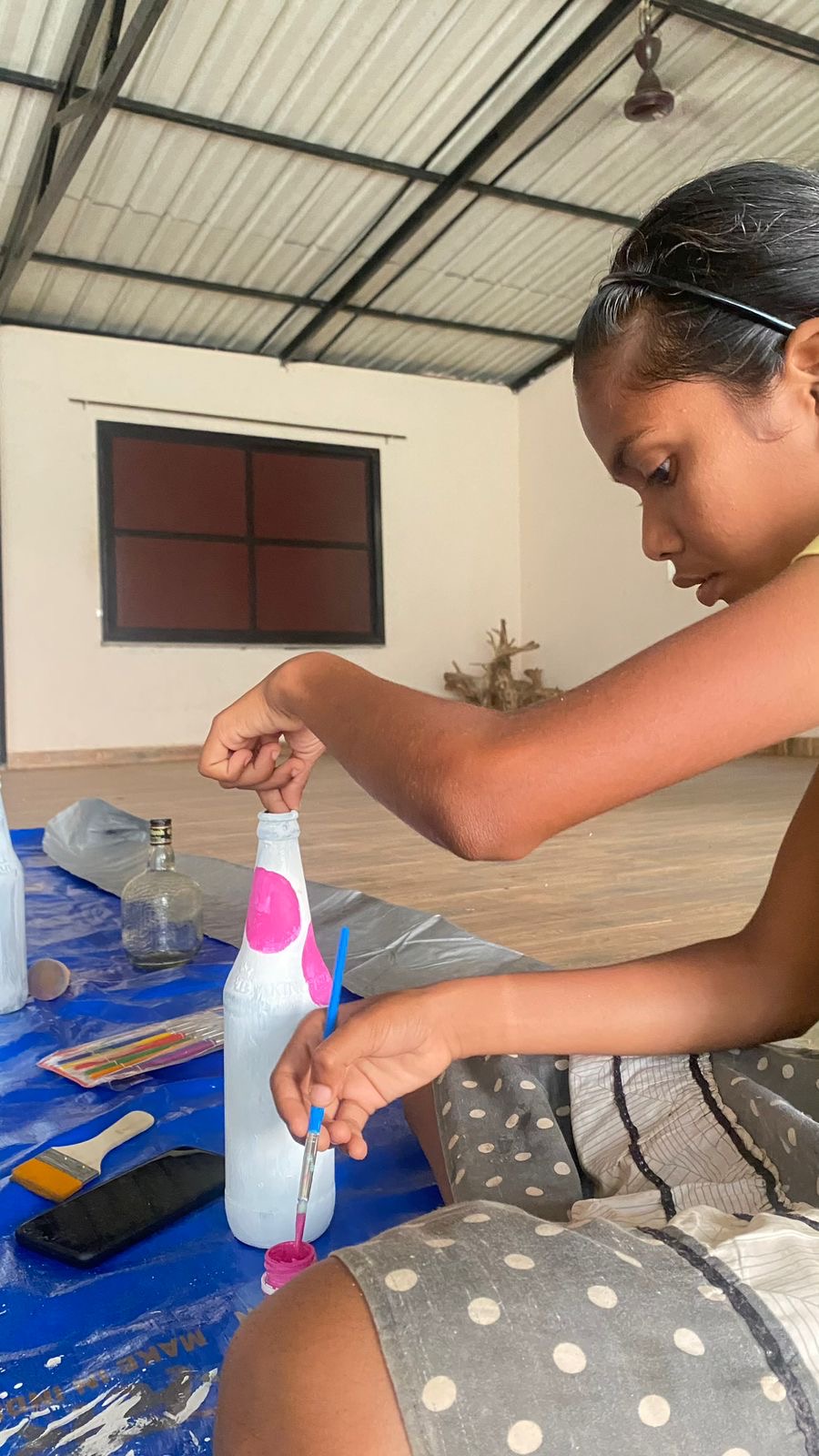 Girl painting bottle close up